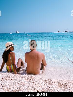 Golfo di Orosei Sardina, hommes et femmes sur la plage Sardaigne Italie, jeune couple vacances Sardaigne Italie, couple hommes et femme jouant dans l'océan avec l'eau bleu clair en Italie Banque D'Images