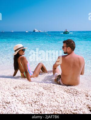 Golfo di Orosei Sardina, hommes et femmes sur la plage Sardaigne Italie, jeune couple vacances Sardaigne Italie, couple hommes et femme jouant dans l'océan avec l'eau bleu clair en Italie Banque D'Images