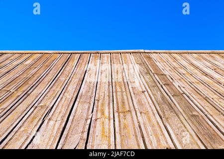 La pente du toit en bois est sous le ciel bleu, vue en perspective avec une mise au point douce sélective Banque D'Images