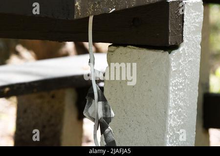 HANGMAN: Un personnage créé en papier fait des bals par le cou d'une table de pique-nique simulant la pendaison d'un homme dans le parc Menlo d'Edison, New Jersey. Banque D'Images