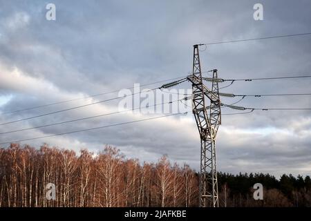 Ligne haute tension contre le ciel. Le pylône de transmission électrique a silhoueté contre le ciel du coucher du soleil Banque D'Images