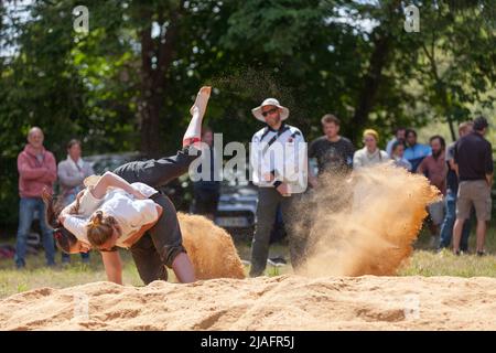 Pleyber-Christ, France - 29 mai 2022 : deux jeunes femmes pratiquant la lutte bretonne (gouren) sur la sciure. Banque D'Images