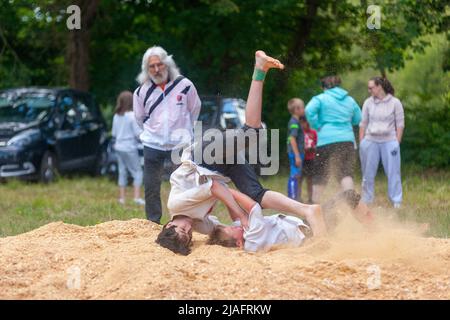 Pleyber-Christ, France - 29 mai 2022 : deux jeunes pratiquant la lutte bretonne (gouren) sur la sciure. Banque D'Images