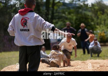 Pleyber-Christ, France - 29 mai 2022: Arbitre en train de faire un match entre deux jeunes pratiquant la lutte bretonne (gouren) sur la sciure. Banque D'Images