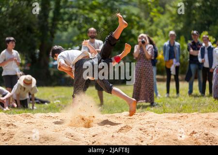 Pleyber-Christ, France - 29 mai 2022 : deux jeunes hommes pratiquant la lutte bretonne (gouren) sur la sciure. Banque D'Images