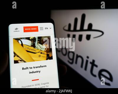 Personne tenant un téléphone portable avec la page web de la société norvégienne de logiciel Cognite COMME sur l'écran devant le logo. Concentrez-vous sur le centre de l'écran du téléphone. Banque D'Images