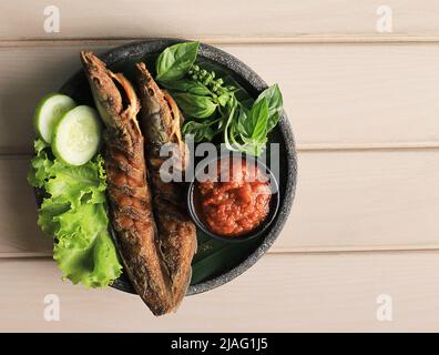 Lele Goreng, poisson-chat frit est une cuisine culinaire traditionnelle indonésienne. Servi sur une assiette en pierre noire avec de la pâte de tomate au Chili ou de la Sambal. Menu célèbre à Pec Banque D'Images