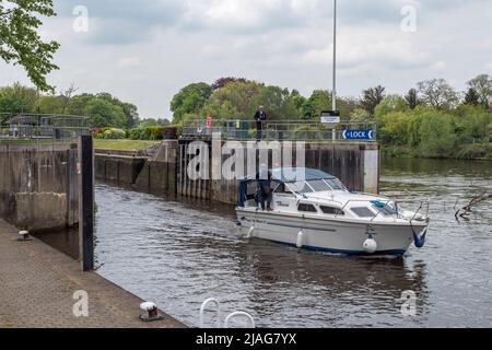 Un petit croiseur qui quitte l'écluse de Molesey sur la Tamise à Hampton, à l'ouest de Londres, au Royaume-Uni. Banque D'Images