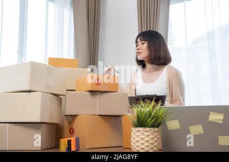 Les femmes asiatiques comptent des boîtes avant d'expédier à leurs clients, de travailler à domicile, les propriétaires de petites entreprises ou les entrepreneurs de petites entreprises commencent tout juste à travailler Banque D'Images