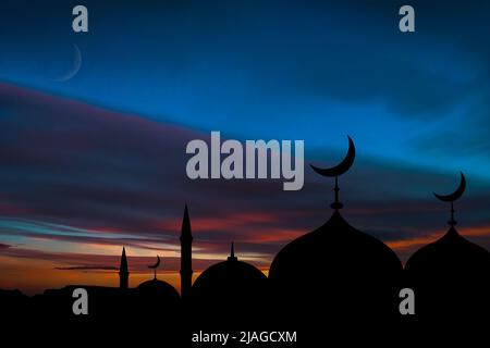 Croissant de lune de la mosquée musulmane sur fond de ciel. Symbole de l'Islam sur le dôme de la mosquée. Silhouettes de bains et minarets islamiques. Concept - croyance Banque D'Images