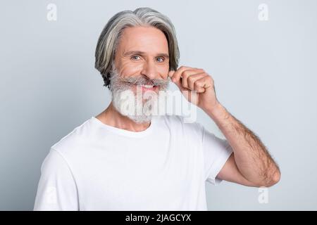 Portrait d'un homme aux cheveux gris bien entretenu et attrayant, avec une moustache isolée sur un fond gris pastel Banque D'Images