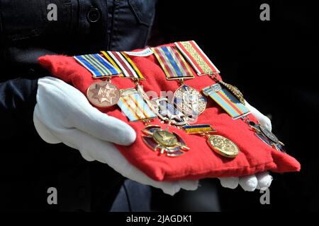 Non exclusif: VINNYTSIA, UKRAINE - 29 MAI 2022 - Un policier tient un coussin avec les médailles de l'un des neuf militaires de la KORD qui ont péri Banque D'Images