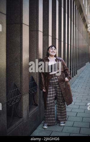 Pleine longueur de jeune femme heureuse debout sur la piste de marche Banque D'Images