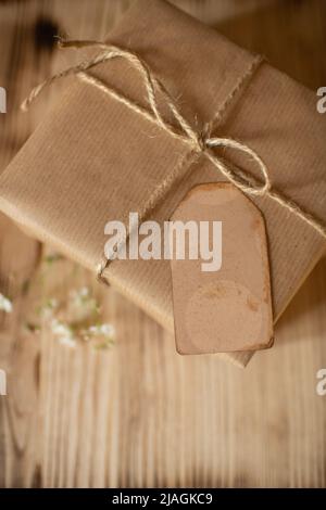 cadeau en papier kraft emballé de façon festive avec une étiquette pour vos souhaits Banque D'Images