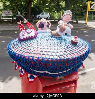 Des personnages tricotés au-dessus d'une boîte postale pour célébrer le Jubilé de platine de la reine Elizabeth en 2022, à Heaton Mersey, Grand Manchester, Angleterre, Royaume-Uni Banque D'Images