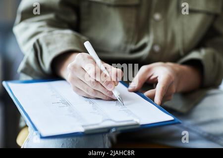 Gros plan de la personne non reconnaissable écrivant sur le presse-papiers avec des notes grammaticales en anglais, espace de copie Banque D'Images