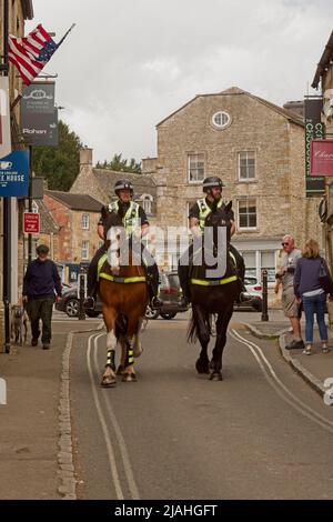 Stow on the Wold, Cotswolds Angleterre police montée du Royaume-Uni côte à côte à cheval le long de la rue de la ville dans un PR de sensibilisation du public Banque D'Images