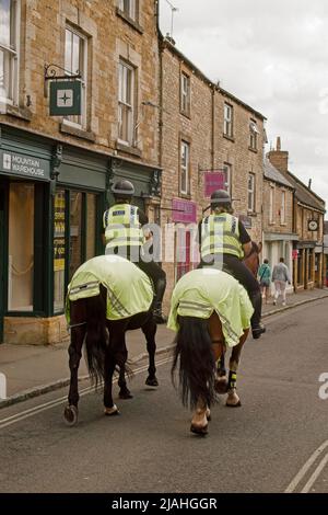 Stow on the Wold, Cotswolds Angleterre police montée du Royaume-Uni côte à côte à cheval le long de la rue de la ville dans un PR de sensibilisation du public Banque D'Images