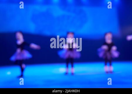 Un arrière-plan abstrait non focalisé d'une danse d'un groupe de filles dans le nombre de trois personnes. Éclairage de scène bleu vif. Photo de haute qualité Banque D'Images