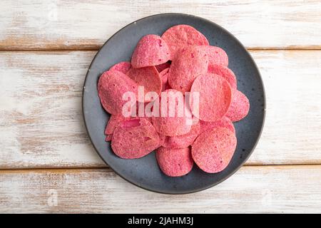 croustilles rouges aux herbes et aux tomates sur fond de bois blanc. Vue de dessus, plan d'installation, gros plan. Banque D'Images