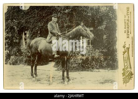 Original carte de charme en plein air portrait d'un homme de campagne sur son cheval à l'extérieur de sa maison, photographié par P.M. Laws, 38 Blackett St. Newcastle-upon-Tyne, Angleterre, Royaume-Uni fin 1880, début 1890. Banque D'Images