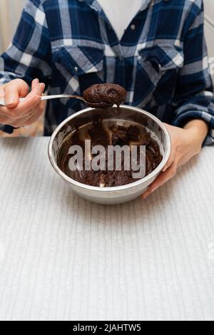 Préparation pour la cuisson du chocolat au brownie, pâte dans un bol en métal. Cuisiner des biscuits à la maison Banque D'Images