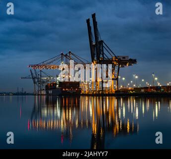 Chargement d'un cargo au terminal à conteneurs de Southampton la nuit, vue de l'autre côté du River Test depuis Marchwood Quay Banque D'Images