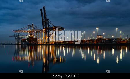 Chargement d'un cargo au terminal à conteneurs de Southampton la nuit, vue de l'autre côté du River Test depuis Marchwood Quay Banque D'Images