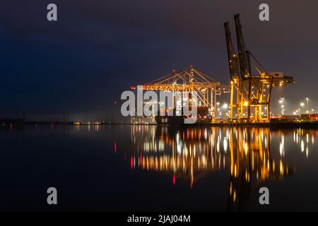 Chargement d'un cargo au terminal à conteneurs de Southampton la nuit, vue de l'autre côté du River Test depuis Marchwood Quay Banque D'Images