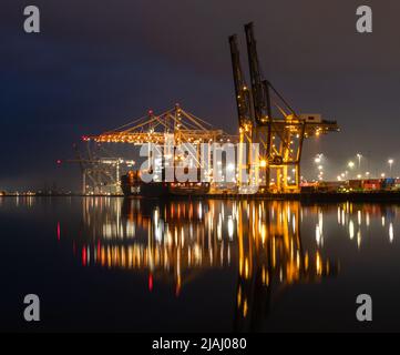 Chargement d'un cargo au terminal à conteneurs de Southampton la nuit, vue de l'autre côté du River Test depuis Marchwood Quay Banque D'Images