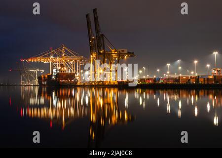 Chargement d'un cargo au terminal à conteneurs de Southampton la nuit, vue de l'autre côté du River Test depuis Marchwood Quay Banque D'Images