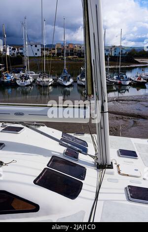 Le mât de yacht et le boom et le pont de yacht se rapprochent avec les yachts à l'ancre à marée basse dans le port de Porthmadog dans le nord du pays de galles au royaume-uni Banque D'Images