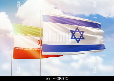 Ciel bleu ensoleillé et drapeaux d'israël et d'iran Banque D'Images