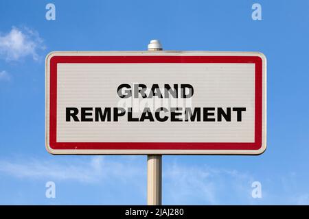 Un signe de ville d'entrée française contre un ciel bleu avec écrit au milieu en français 'Grand remplacement', signifiant en anglais 'Grand remplacement'. Banque D'Images