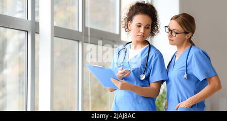 Les femmes médecins discutant du diagnostic dans le hall de la clinique moderne Banque D'Images