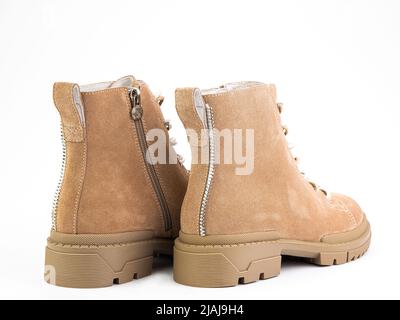 Bottes en daim beige avec lacets beige et fermeture à glissière sur le côté. Détails élastiques sur les côtés et semelle en caoutchouc. Gros plan isolé sur fond blanc. Arrière Banque D'Images