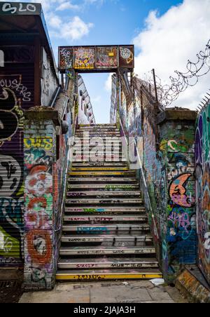 Une passerelle couverte de grafitti et d'art de la rue au-dessus du chemin de fer sur Cheshire Street près de Brick Lane dans l'extrémité est de Londres, Royaume-Uni. Banque D'Images