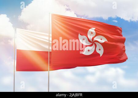 Ciel bleu ensoleillé et drapeaux de hong kong et de pologne Banque D'Images