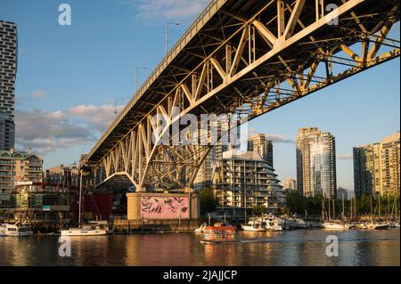 Le traversier du port de Vancouver False Creek traverse sous le pont de la rue Granville, dans la zone touristique de Granville Island. Banque D'Images