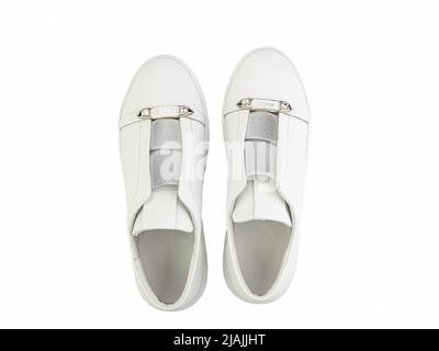 Baskets en cuir blanc. Style décontracté pour femmes. Laçage blanc et semelles en caoutchouc blanc. Gros plan isolé sur fond blanc. Vue de dessus. Chaussures de mode Banque D'Images
