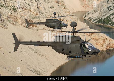 Une paire d'hélicoptères d'attaque Kiowa Warrior de la Force aérienne croate OH-58 capturés en vol, en Croatie. Banque D'Images