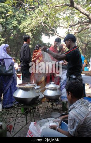 Bhapa pitha (gâteaux de riz vapeur) vendu à l'extérieur de l'Institut des Beaux-Arts où des centaines de personnes se réunissent pour participer aux célébrations de Nobanno Utshob ou Harvest Festival qui a lieu chaque année en novembre. Dhaka, Bangladesh. Banque D'Images