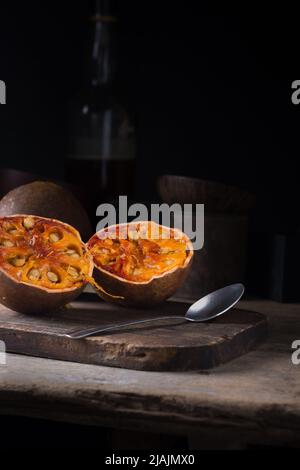 fruit mûr de bale, également connu sous le nom de coing bengale, pomme dorée ou pomme de pierre, doux aromatique, avantages médicinaux fruit sur table avec fond sombre Banque D'Images