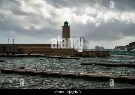Tempête sur mer, hautes vagues dans le vieux port de pêcheur avec phare à Cassis, Provence, France Banque D'Images
