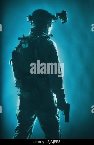 Soldat des forces spéciales de l'armée avec dispositif de vision nocturne et pistolet, prêt à l'action. Banque D'Images