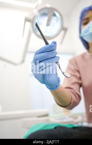 mains portant des gants chirurgicaux, tenant des instruments professionnels dentaires, intérieur de bureau, objet moderne, soins de santé et traitement Banque D'Images