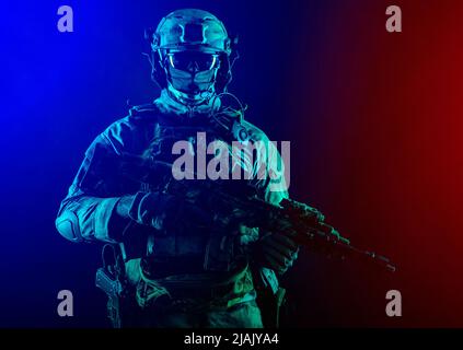 Les opérations spéciales militaire portent un masque, armé d'un canon de sous-machine, sur fond coloré. Banque D'Images