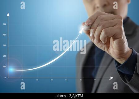 Homme d'affaires présentant les performances de l'entreprise en dessinant un graphique exponentiel des progrès de l'entreprise Banque D'Images