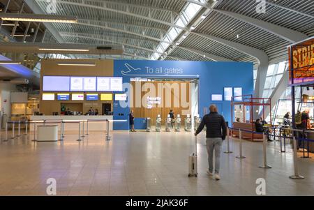Homme avec valise à pied vers la sécurité et toutes les portes de l'aéroport international d'Eindhoven Banque D'Images