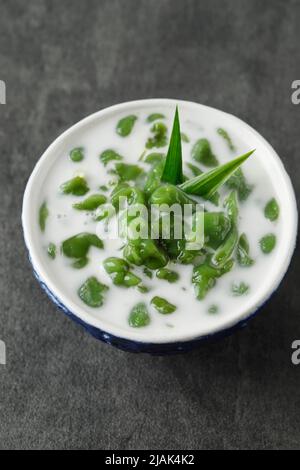 Es Cendol ou Dawet est un dessert traditionnel indonésien glacé à base de farine de riz, de sucre de palme, de lait de noix de coco et de feuilles de Pandan servi dans un bol bleu. Populaire Banque D'Images